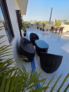 a patio with black chairs and a blue table at Ghare Stays Udaipur in Udaipur