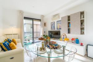 a living room with a glass table and a couch at Suite Des Etrangers -Parcheggio privato- Private parking in Sanremo