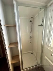 a walk in shower with a glass door at Mobilhome les 3C de mimizan in Mimizan +14 photos