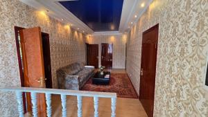 a living room with a couch and a stair case at 华人民宿 in Almaty