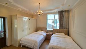 a bedroom with two beds and a chandelier at 华人民宿 in Almaty