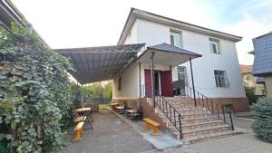 a house with a porch with stairs and a fence at 华人民宿 in Almaty