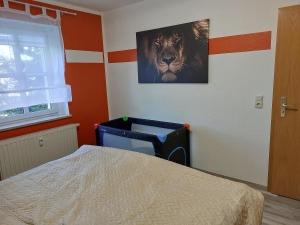 a bedroom with a bed and a picture of a lion at Apartment Erzgebirgsperle in Schwarzenberg