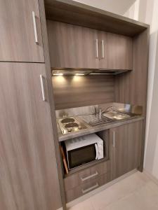 a small kitchen with a microwave and a sink at Casa Vacanze Piccolpasso 20 in Urbania