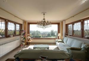 a living room with a couch and a chandelier at Linda's Retreat in Fiano Romano