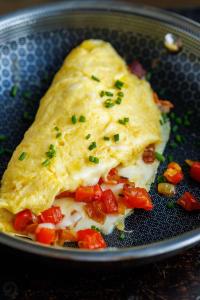 a omelet in a plate with tomatoes and cheese at Byblos inn, jbeil ,Fidar in Al Fīdār
