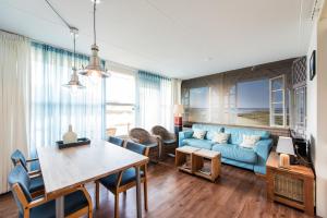 a living room with a blue couch and a table at Vleijenhof Type B in Buren