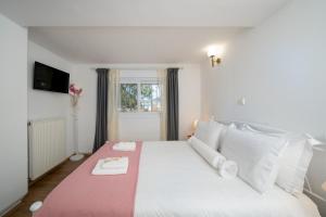 a bedroom with a large white bed with white pillows at Livingstone House in Porto Rafti