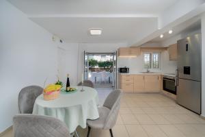a kitchen and dining room with a table and chairs at Livingstone House in Porto Rafti