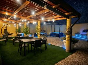 a patio with a table and chairs and lights at Costa Ovest Apartment Waves in Nurachi