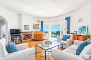 a living room with two white couches and a table at Villa Caprice by Villa Plus in S'Algar