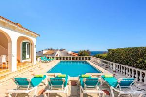 a villa with a swimming pool and chairs at Villa Caprice by Villa Plus in S'Algar
