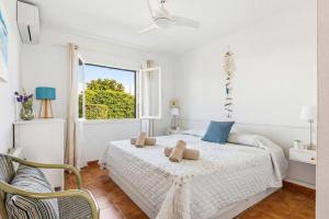 a white bedroom with a bed and a window at Villa Caprice by Villa Plus in S'Algar +14 photos