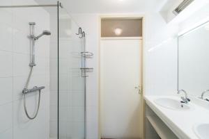 a bathroom with a glass shower and a sink at Vleijenhof Type B in Buren +17 photos