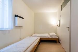 a small room with two beds and a window at Vleijenhof Type B in Buren
