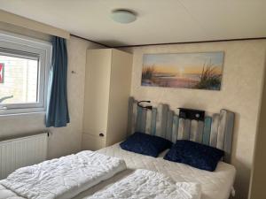 a bedroom with a bed and a window at Lieblingsplatz Renesse, Camping Siblu de Oase in Renesse