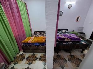 a bedroom with two beds and colorful curtains at Hotel Himalayan dews in Ukhimath