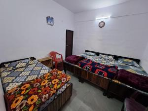 a room with two beds and a clock on the wall at Hotel Himalayan dews in Ukhimath +8 photos