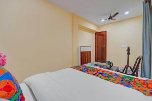 a bedroom with a bed and a desk with a table at Via Shree Gopal Inn in Varanasi