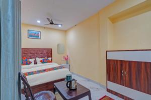 a bedroom with a bed and a table in a room at Via Shree Gopal Inn in Varanasi