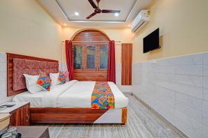 a bedroom with a bed and a television in it at Via Shree Gopal Inn in Varanasi