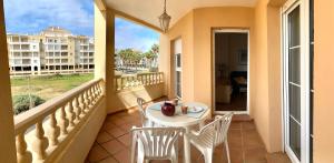 a balcony with a table and chairs and a view of a building at Apartamentos Isla Canela y Punta del Moral in Isla Canela