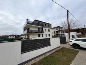 a white house with a car parked in front of it at Rupphill Apartment in Budapest
