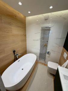a bathroom with a large white tub and a toilet at Rupphill Apartment in Budapest +11 photos