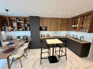 a kitchen with wooden cabinets and a table and chairs at Rupphill Apartment in Budapest