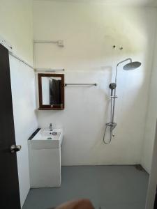a bathroom with a shower with a sink and a mirror at Bella Sunset Point in Embilipitiya