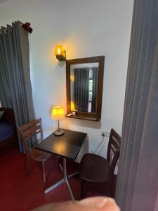 a room with a table with a lamp and a mirror at Bella Sunset Point in Embilipitiya +15 photos