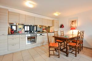 a kitchen with a wooden table and chairs and a table and a table at FeWo im Chalet Schneeflöckli in La Tzoumaz