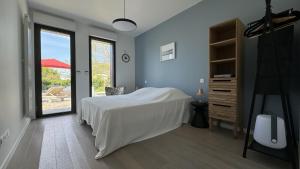 a bedroom with a white bed and a window at Villa Koad - piscine privee in Trébeurden