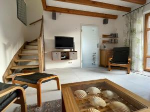 a living room with stairs and a room with shells at Ferienhaus Uferweg in Otterndorf