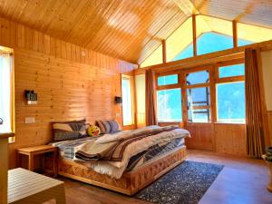 a bedroom with a bed in a wooden cabin at River View Sunrise Cottages Tirthan Valley in Kulu