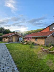 a house with a grass yard next to a building at Chalet Hüttendorf 49 gradnord in Bayerisch Eisenstein