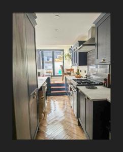 a kitchen with stainless steel appliances and a large window at Spacious House In Guildford in Stoughton +5 photos
