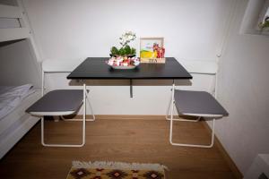 a small table with two chairs and a black table at Bosanska Avlija Authentic Sarajevo Stay with Garden in Sarajevo