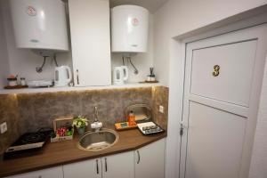 a kitchen counter with a sink and white cabinets at Bosanska Avlija Authentic Sarajevo Stay with Garden in Sarajevo +54 photos