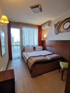 ein Schlafzimmer mit einem Bett und einem großen Fenster in der Unterkunft Hotel Villa Pax in Balatonalmádi + 66 Fotos