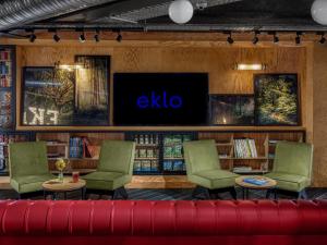 a library with a tv and a red couch at Eklo Hotels Paris Marne La Vallée in Serris