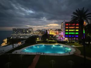 a large swimming pool in a city at night at La Roca Sea View Luxury Apartment Beach Elevator in Torremolinos