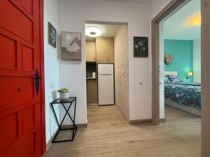a hallway with a red door and a bedroom at La Roca Sea View Luxury Apartment Beach Elevator in Torremolinos