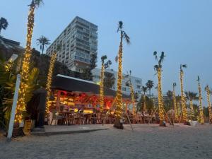 a beach with a restaurant with palm trees and lights at La Roca Sea View Luxury Apartment Beach Elevator in Torremolinos