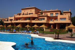 a resort with people swimming in a swimming pool at Marbella Beach Resort at Club Playa Real in Marbella