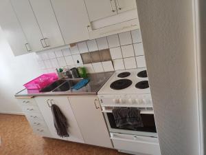 a small kitchen with a stove and a sink at Karl Cozy stay in Örebro