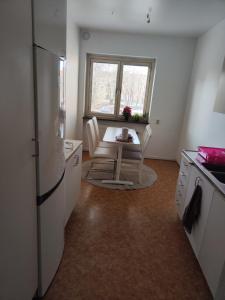 a kitchen with a table and a refrigerator and a window at Karl Cozy stay in Örebro +4 photos
