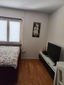 a bedroom with a bed and a flat screen tv at Karl Cozy stay in Örebro