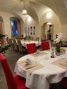 a dining room with white tables and red chairs at Stadtpalais Domblick-Suite 4 Zimmer mit Balkon maximal 6 Personen in Bautzen
