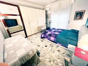 a bedroom with a bed and a couch and a tv at Il Broletto B&B in Novara